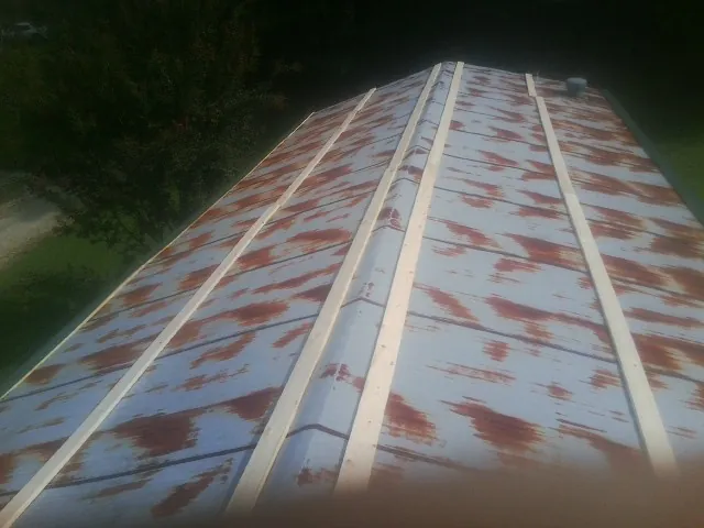 Rusted metal roof panels with new wood purlins before replacement — Storm Damage Roof Repair in Goodland by Roofing Brothers